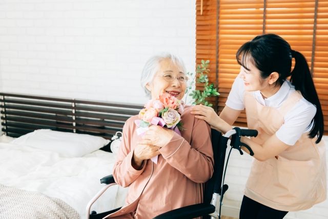 高齢者に花を挙げる女性